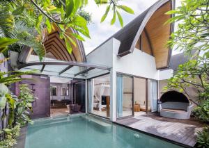 an external view of a house with a swimming pool at Lalasa Villas Canggu in Canggu