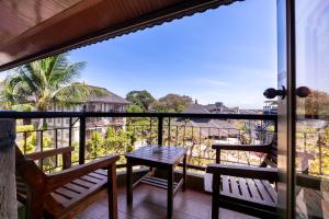 a balcony with two benches and a table and a view at Private Apartment 6503 at the Jayakarta Residence in Seminyak