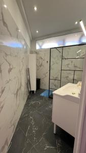 baño con lavabo blanco y paredes de mármol en LE REX Nice, en Niza