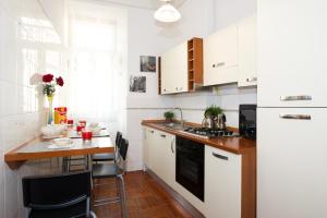 a small kitchen with white cabinets and a counter at Holiday Home House Fornaci in Rome