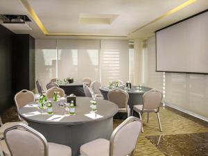 安曼The Abdali Boulevard Hotel的配有桌椅和投影屏幕的会议室 更多37张照片