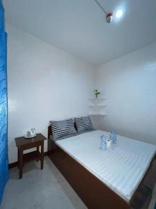a small bedroom with a bed and a table at Love Vega Hometel in El Nido +12 photos