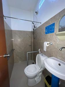a bathroom with a toilet and a sink at Love Vega Hometel in El Nido