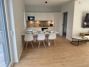 a kitchen and dining room with a table and chairs at Appartement NEUF, 6 personnes, 2 chambres in Ohligsmühle