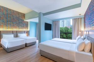 een slaapkamer met twee bedden en een groot raam bij ibis Styles Kuala Lumpur Bukit Bintang in Kuala Lumpur