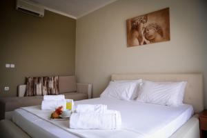 a bedroom with a white bed with towels on it at Crown Resort by Diomedes Group in Nea Skioni
