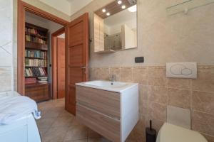 un bagno con lavandino e specchio di La Terrazza sul Golfo di Alghero 1 ad Alghero Altre 36 foto