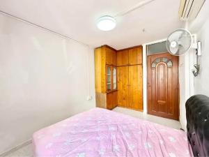 ムンバイにあるRoom Sunshineのベッドルーム1室(ピンクベッド1台、木製のドア付)