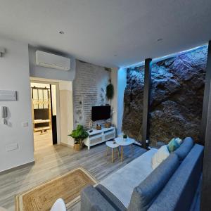 a living room with a blue couch and a tv at El susurro del tajo La gruta in Toledo +31 photos
