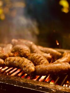a bunch of sausages and sausage on a grill at Richiland Tea Estate Bungalow in Deniyaya