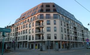 a large white building on a city street at Apartamenty Młynowa in Białystok