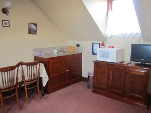 a living room with a tv and a desk with a microwave at Sorell Barracks in Sorell