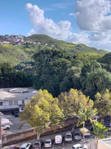 - un parking avec des voitures garées devant une montagne dans l'établissement Apto central com estacionamento, à Poços de Caldas