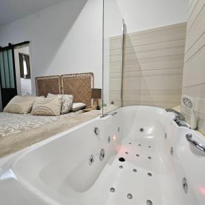 a white bath tub in a room with a bed at El susurro del tajo La gruta in Toledo