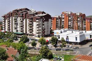 a large apartment building in a city with a parking lot at Trade Centre View in Kočani