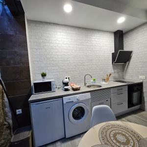 a kitchen with a washing machine and a sink at El susurro del tajo La gruta in Toledo