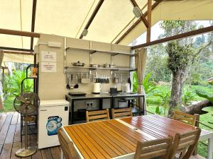 an outdoor kitchen with a wooden table and a wooden table at Canopy Villa Nuang Hill in Bentong