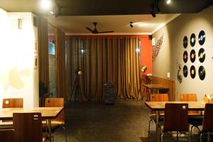 a dining room with tables and chairs and a curtain at Haven Hotel Sector 31,Gurugram in Gurgaon