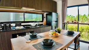 a kitchen with a table with bowls of fruit on it at 8 Valley KhaoYai in Ban Tha Chang