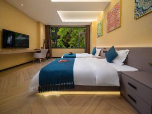 a large bedroom with a large bed and a television at Yun Guan Shunde Renjia Resort Hotel in Jinghong
