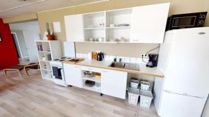 una cucina con armadietti bianchi e frigorifero bianco di Brenna - Ocean View Apartment a Hellissandur