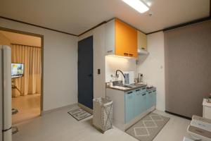 une cuisine avec des armoires bleues et un évier dans l'établissement Walking Distance to Sindorim Station, 3 Rooms, 4 Queen Beds, 2 Bathrooms, 1 Minute to Yeongdeungpo Station Bus Stop, à Séoul