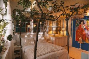 1 dormitorio con cama con dosel y árbol en Mondo Diverso, en Liubliana