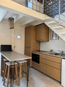 a kitchen with a table and some stairs at Maison cosy, wifi terrasse, proche plage, gare, centre in Arcachon