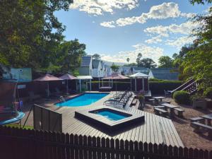 un patio trasero con piscina y una valla de madera en Sunset Nest & Seabreeze Shores, en Knysna