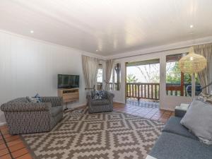 Una sala de estar con dos sofás y un televisor. en Sunset Nest & Seabreeze Shores, en Knysna