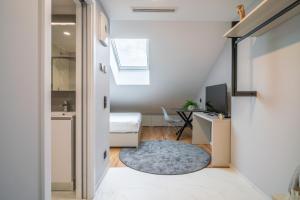 a small apartment with a hallway with a bed and a desk at City Pop Prague Aparthotel in Prague