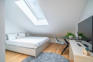 a bedroom with a bed and a desk with a computer at City Pop Prague Aparthotel in Prague