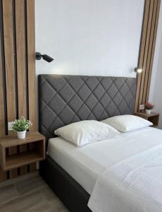 a bedroom with a large bed with a gray headboard at Apartment Complex with Pool in Bar, Montenegro in Bar +27 photos