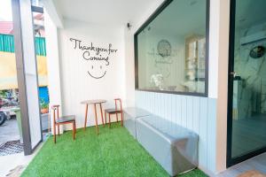 a shop with two chairs and a table and a window at Phunaya Phuket Oldtown Hotel in Phuket