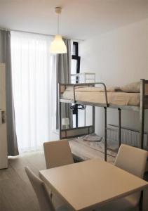 a room with two bunk beds and a table and chairs at Hauptbahnhof 32 in Vienna