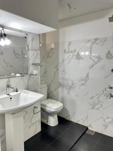 a white bathroom with a sink and a toilet at Himo Guest Inn in Dehiwala +83 photos