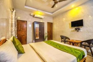 a bedroom with a bed and a table and a television at Calangute Sea Steps in Calangute