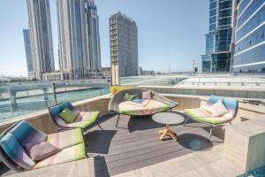 a deck with chairs and a table on a building at Aven Apartment Dubai 2BR-2209 in Urban Oasis by Missoni-Business Bay Dubai in Ghantoot