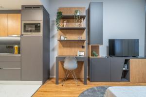 a kitchen with a desk with a chair and a tv at City Pop Prague Aparthotel in Prague
