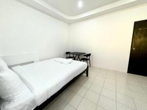 Un pequeño dormitorio con una cama y una mesa. en Patong Canal Villa 107, en Patong Beach