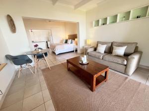 a living room with a couch and a table at Beachbreak Cottages in Durban