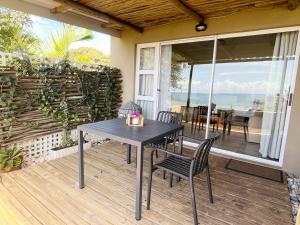 a table and chairs on a patio with a view of the ocean at Beachbreak Cottages in Durban