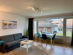 a living room with a couch and a table with chairs at Poseidon 1 6 in Wangerooge