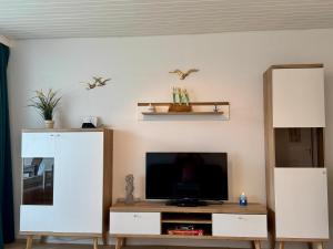 a living room with a flat screen tv on a table at Poseidon 1 6 in Wangerooge +1 photo