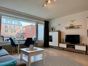 a living room with a couch and a tv and a table at Poseidon 1 6 in Wangerooge