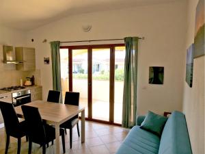 a living room with a table and a blue couch at Appartamento Estate in Limpiddu