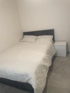 a bedroom with a bed with a white comforter at DFL's Lovely Home in Rotherham