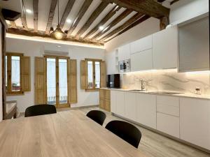 une grande cuisine avec une table et des chaises en bois dans l'établissement El Patio de Vespasiano- San Juan- vistas al ayuntamiento junto al puerto, à Castro Urdiales