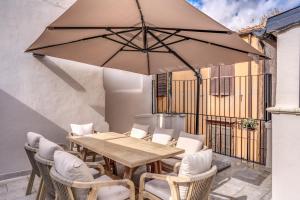 a patio with a table and chairs and an umbrella at Maison Della Vite in Rome