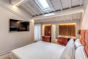 a bedroom with a white bed and a desk at Maison Della Vite in Rome